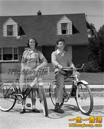 846-05646091em-1950s-SMILING-TEENS-ON-SUBURBAN-STREET-BOY-SITTING-ON-BIKE-GIRL-STANDI.jpg