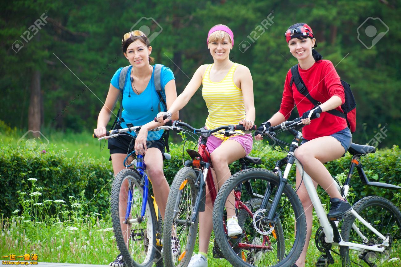 21462683-Young-pretty-women-race-on-bicycle-in-green-park-Stock-Photo.jpg