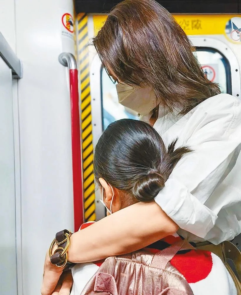 黎姿在車廂中護著囡囡。.jpg