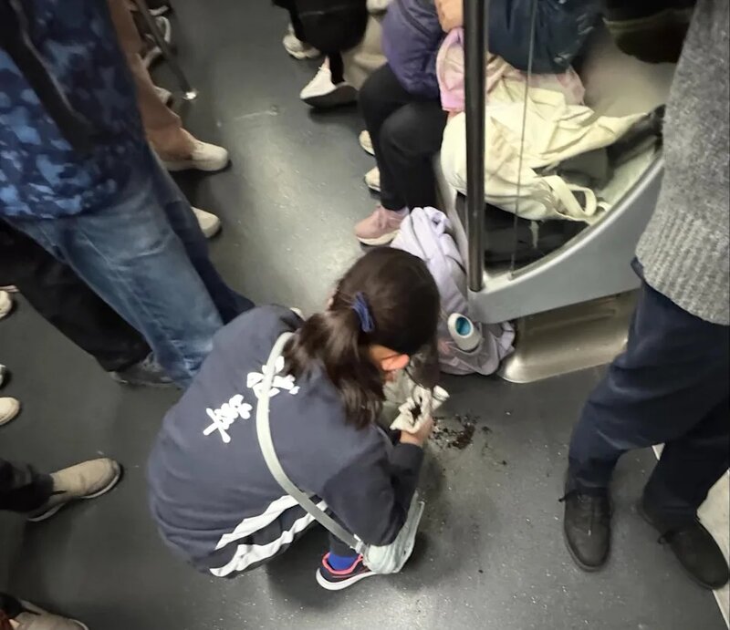 一個穿着拔萃體育服的女生在港鐵不慎倒瀉盆栽，令泥土散落一地。她立即拿出紙巾清理，.jpg