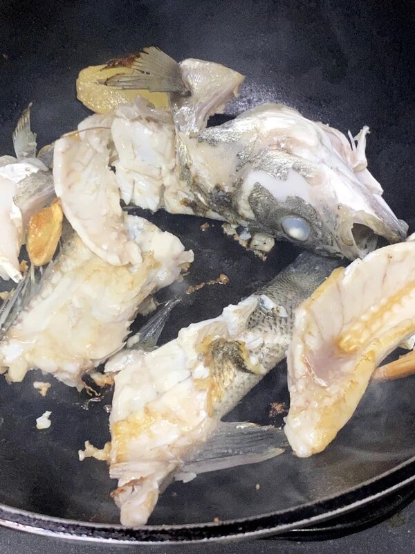 2 鱸魚起魚柳，切塊。頭和骨斬段。薑切片。燒熱鑊，加油，放薑片爆香，再加入魚頭和骨.jpg
