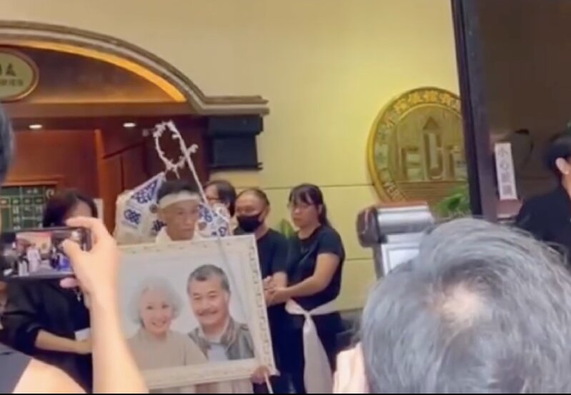 2 親屬捧住唐佳同雪妮嘅遺照離開殯儀館（TVB娛樂新聞台截圖）.jpg