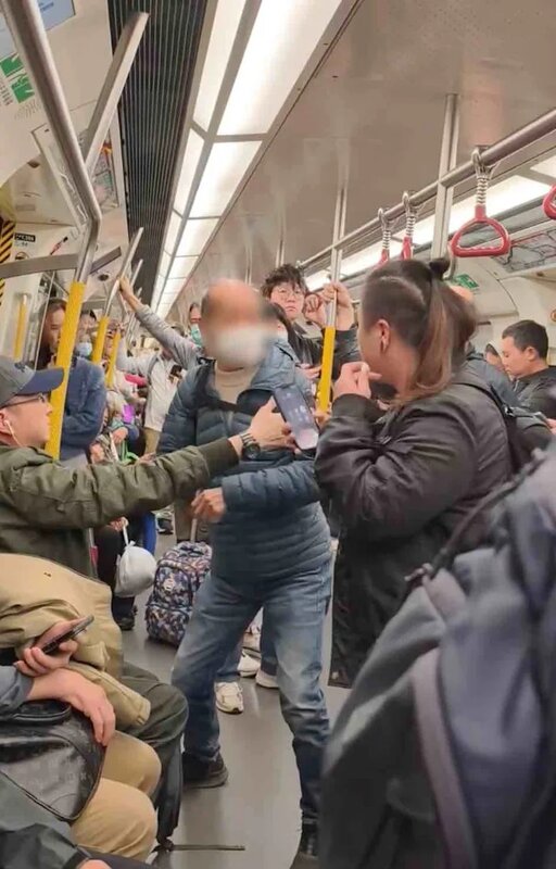 2 男乘客揮拳襲擊女乘客面部時，座位上一名男乘客出手阻止。（片段截圖）.jpg