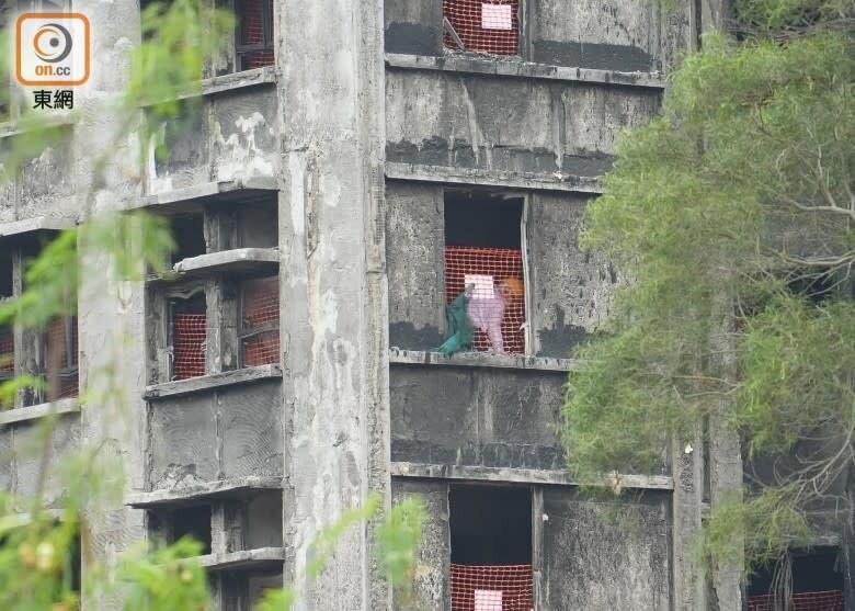 1 有居民在四樓一單位內，在已燒成沒有窗框的窗口附近執拾。（袁志豪攝）.jpg