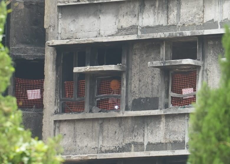 3 有居民在單內檢視期不忘憑窗望望外面情況。（袁志豪攝）.jpg